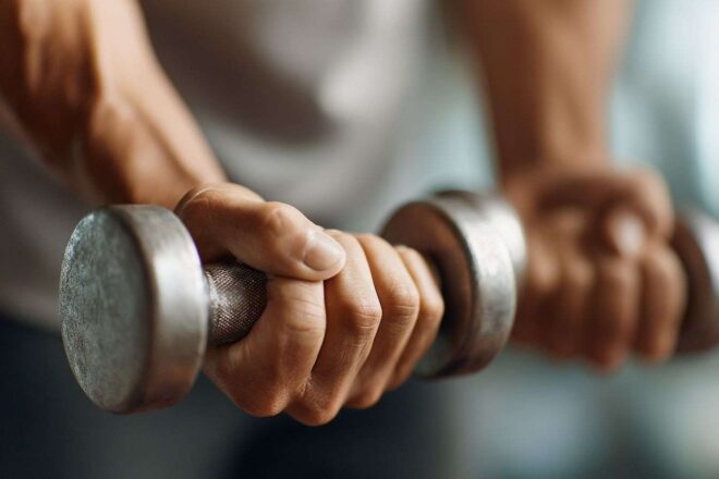 Gros plan des mains tenant des haltères